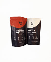 Two stand-up pouches of Inna Protein Pancakes shown on a plain white background. The left pouch is chocolate flavour with a red top section and dark brown lower section.