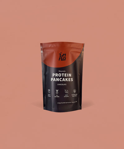 A stand-up pouch of Inna Protein Pancakes in Chocolate flavour, set against a solid terracotta background.