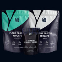 Three stand-up pouches of Inna Protein performance protein powder arranged together on a dark background: a teal and navy Plant Protein Isolate unflavoured pouch, a black and navy Creatine Monohydrate pouch in the center, and a white and navy Plant Protein Isolate vanilla pouch on the right.