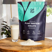 Inna Protein plant protein isolate package with a glass of protein shake on a wooden surface.