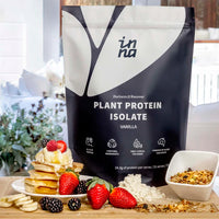 Inna Protein package with a stack of pancakes, berries, and granola on a table.